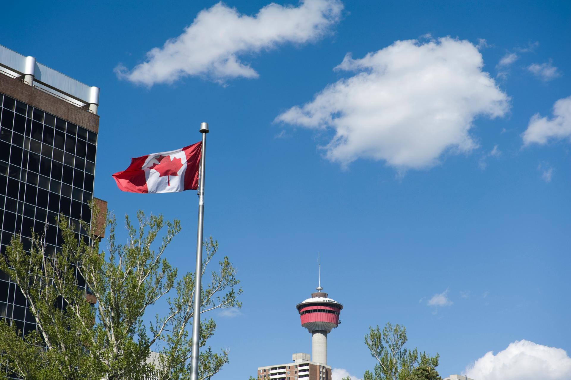 Canadian flag with Calgary tower seen from central memorial park